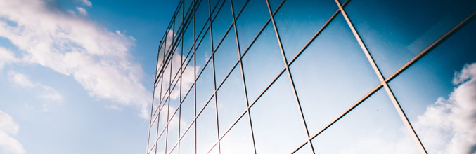 Rolls Royce office window with reflections of the sky and clouds